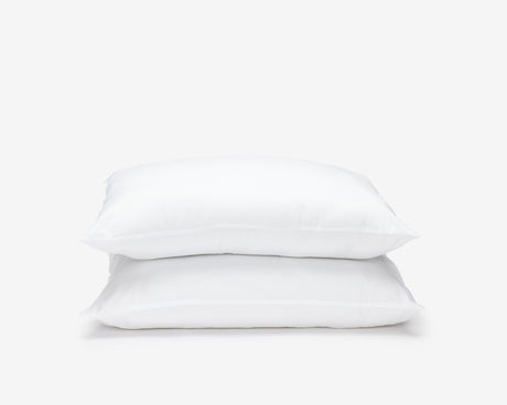 Two white vintex hotel pillow forming a pile