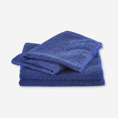 Blue microfiber dishcloth folded on a white background.