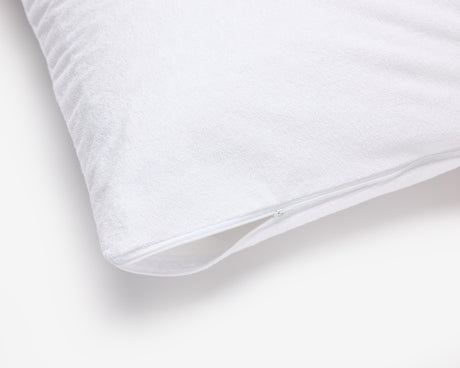 Corner of a hotel pillow featuring a white waterproof pillow protector.